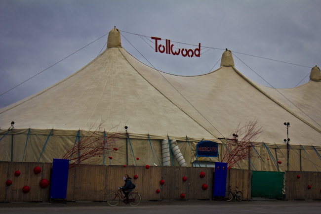 White tent and red Tollwood sign at the Tollwood Winter Festival in Munich.