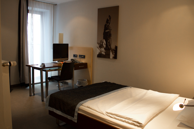 Single room with a bed and desk at Schiller5 Hotel in Munich, Germany.
