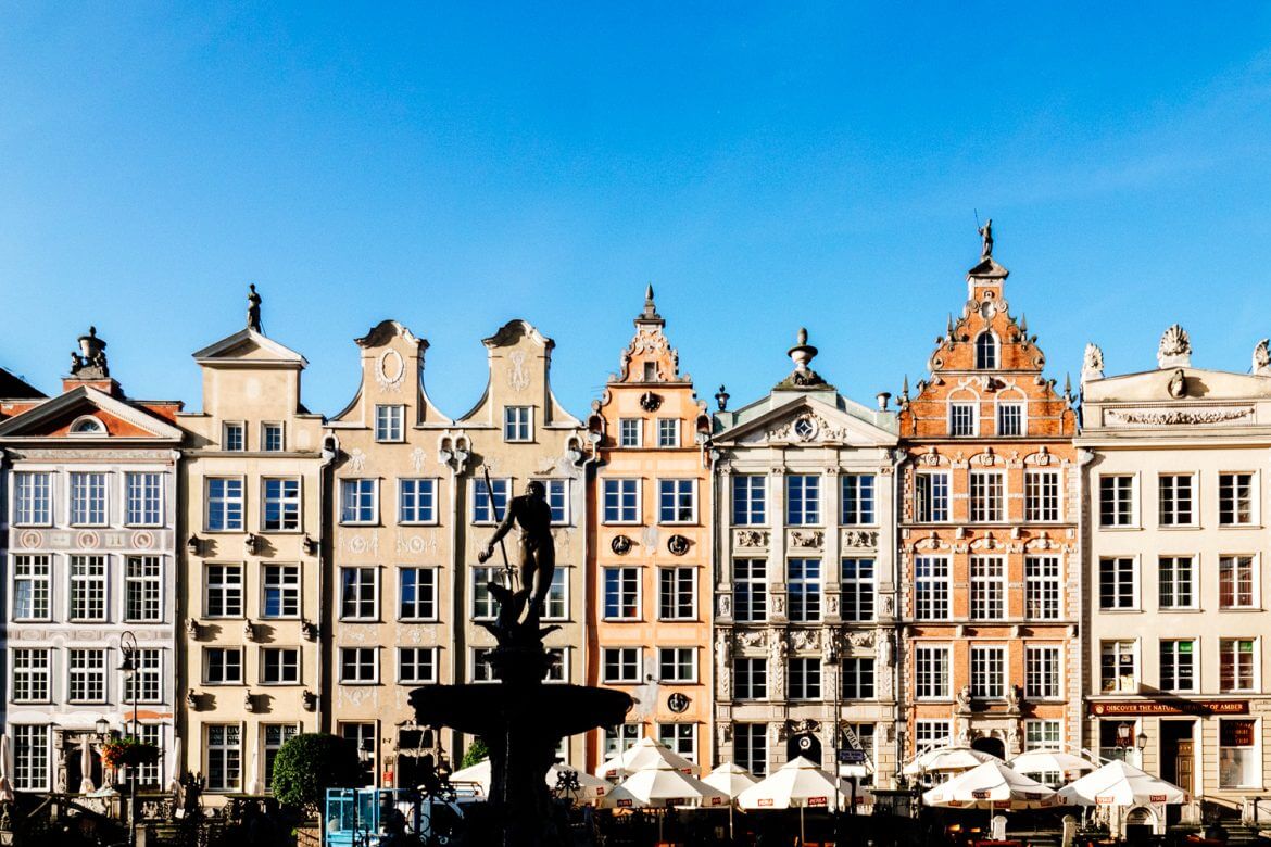 Gabled buildings in Gdansk's Long Market with the silhouette of Neptune's Fountain. 