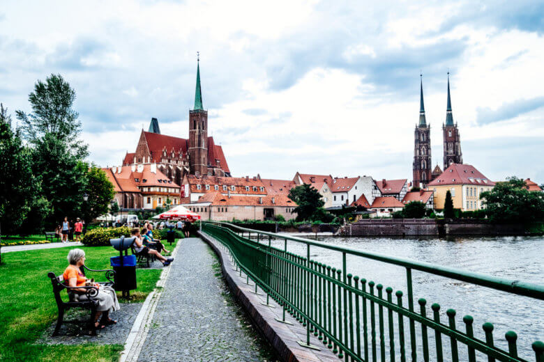 Cathedral Island with it's red roofs and people sitting by the water. 