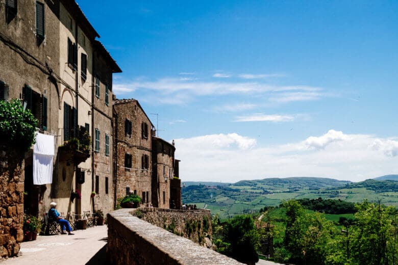The hilltop town of Pienza, with historic stone buildings and the rolling Tuscan hills in the background.