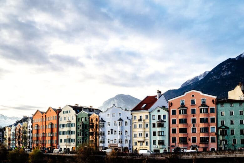 Pastel-coloured buildings along the river in Innsbruck in December.