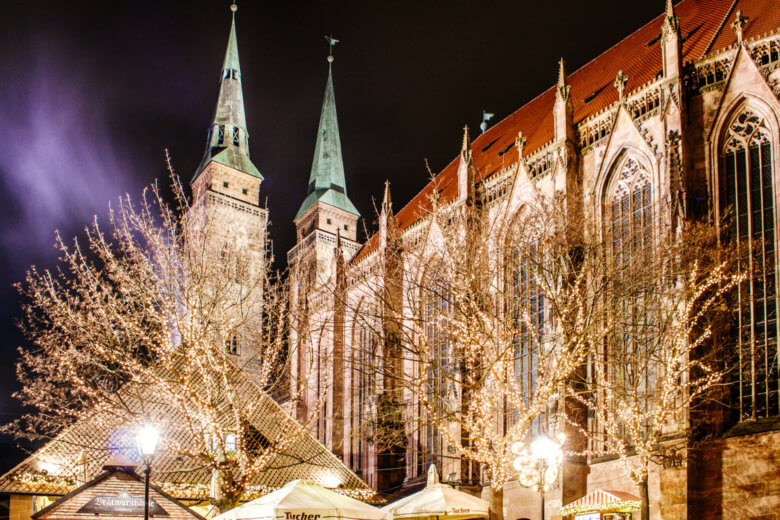 Nuremberg Christmas Market at night with fairy lights in the trees.
